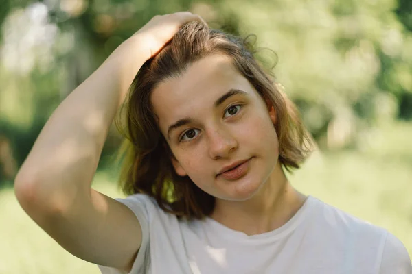 Gyönyörű fiatal tini lány egy divatos Bob haj egy fehér póló a szabadban, és nézi a kamerát. — Stock Fotó