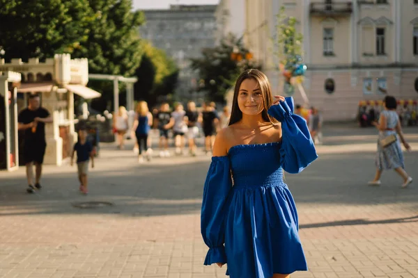 Retrato feliz jovem mulher vestindo vestido azul rindo olhando para a câmera de pé na rua. Fundo urbano — Fotografia de Stock