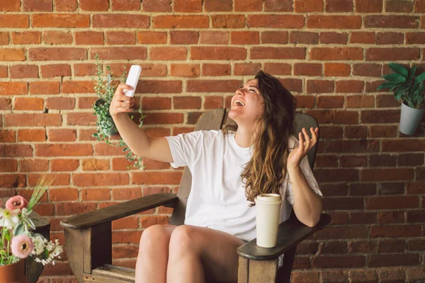 Genç bir kadın telefonda video görüşmesiyle gülüyor ve konuşuyor. Yaşam tarzı hareketliliği kavramı — Stok fotoğraf