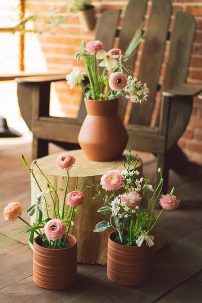 Ranunculus flowers in clay pots on the terrace. Beautiful flowers in a vase — Stock Photo, Image