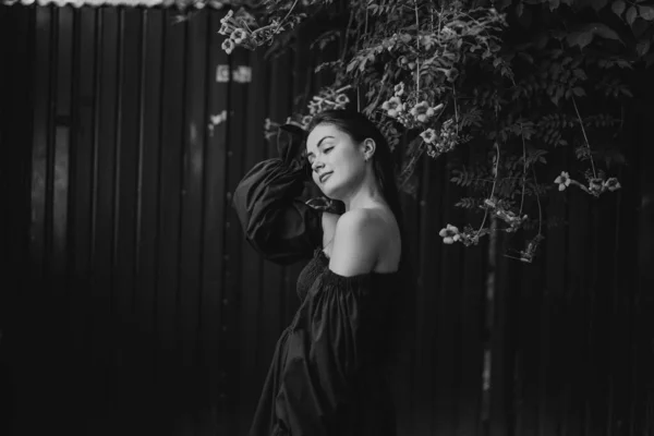 Retrato feliz jovem mulher vestindo vestido azul e de pé em Campsis radicans flores — Fotografia de Stock