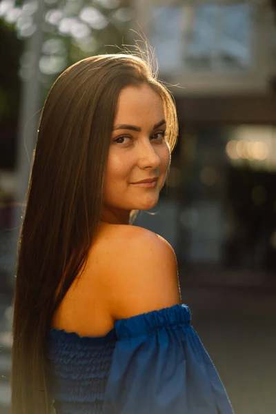 Porträt einer glücklichen jungen Frau in blauem Kleid, die lachend in die auf der Straße stehende Kamera blickt. Urbaner Hintergrund — Stockfoto