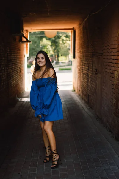 Retrato mujer joven feliz vistiendo vestido azul riendo mirando a la cámara de pie en la calle. Fondo urbano — Foto de Stock