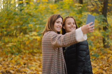 Kızlar güler ve telefonda selfie çeker. Yaşam tarzı hareketliliği kavramı