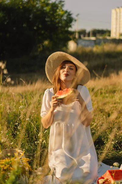 สาวที่มีความสุขในสวนกลางแจ้งกับผลไม้มะพร้าวสดชื่น ผู้หญิงกินแตงโมชิ้นหนึ่ง — ภาพถ่ายสต็อก