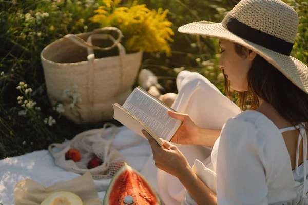 Mujer joven leyendo libro en el campo al aire libre. Lectura y relajación — Foto de Stock