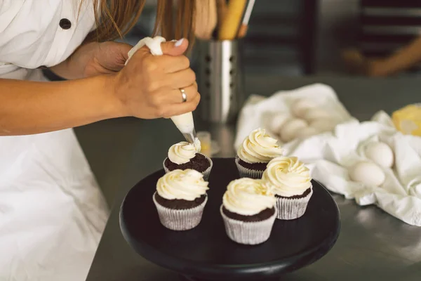 Suikerbakkersmeisje bereidt een cupcake. Concept ingrediënten voor het koken van meelproducten of dessert — Stockfoto