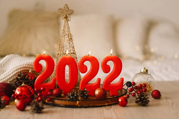 Szczęśliwego Nowego Roku 2022. Numery roku 2022 wykonane przez czerwone świece na bokeh świąteczne musujące tło — Zdjęcie stockowe