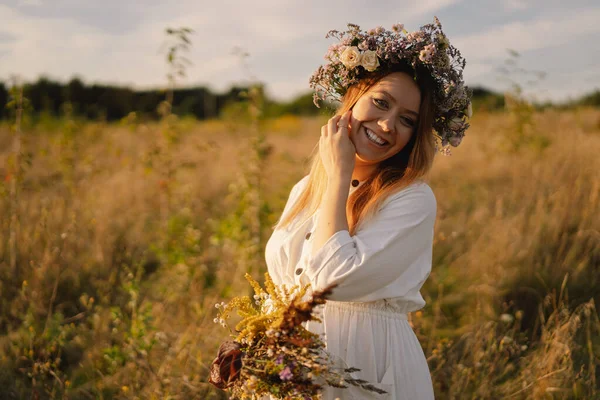 Retrato de uma mulher grávida. Uma bela jovem grávida em um vestido branco caminha no campo. — Fotografia de Stock