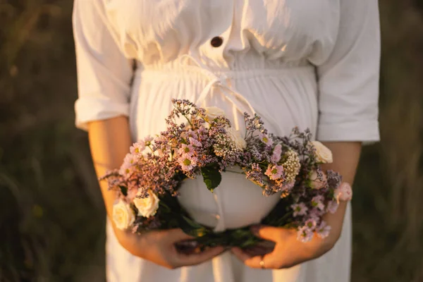 Porträtt av en gravid kvinna. En vacker ung gravid kvinna i vit klänning går i fält. — Stockfoto