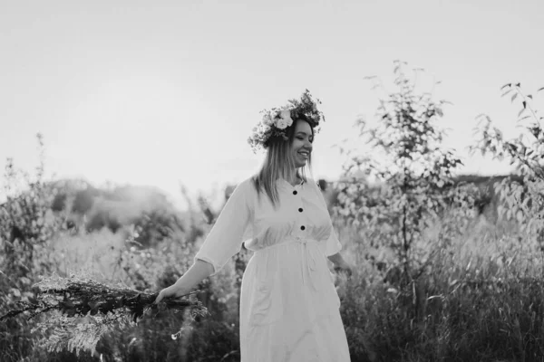 Portret van een zwangere vrouw. Een mooie jonge zwangere vrouw in een witte jurk loopt in het veld. — Stockfoto