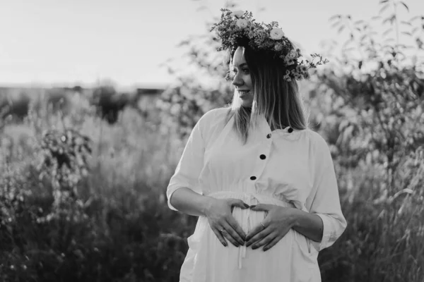 Ritratto di donna incinta. Una bella giovane donna incinta in un abito bianco cammina sul campo. — Foto Stock