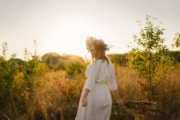 Porträt einer schwangeren Frau. Eine schöne junge schwangere Frau in einem weißen Kleid geht auf das Feld. — Stockfoto