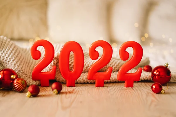 สุขสันต์วันปีใหม่ 2022. ตัวเลขของปี 2022 ทําโดยเทียนสีแดงบนพื้นหลังที่ส่องแสงเทศกาล bokeh — ภาพถ่ายสต็อก