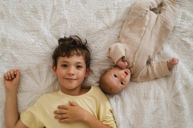 Two little boys brothers enjoying playing in cozy bright bedroom, smiling and playing. Happy childhood. Children portraits.