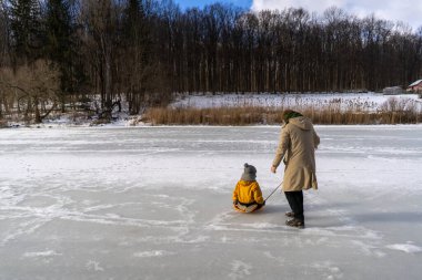 In a serene winter forest, a son and father have a great time, both dressed in warm clothes. The scene captures a moment of love against a snowy backdrop, evoking warmth and connection. Fathers Day