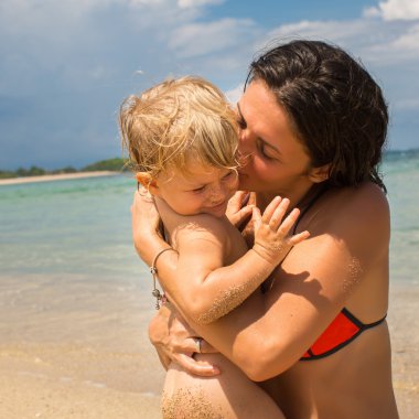 Genç anne küçük kızıyla birlikte sahilde oynarken