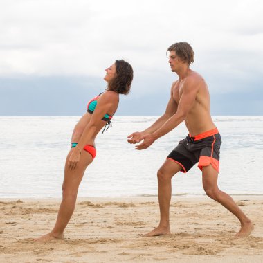 Genç çift güven tropikal bir plajda bir egzersiz pratik