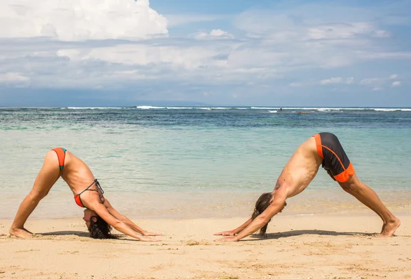 Denizin kenarında Yoga ve gevşeme egzersizleri yapıyor Çift — Stok fotoğraf