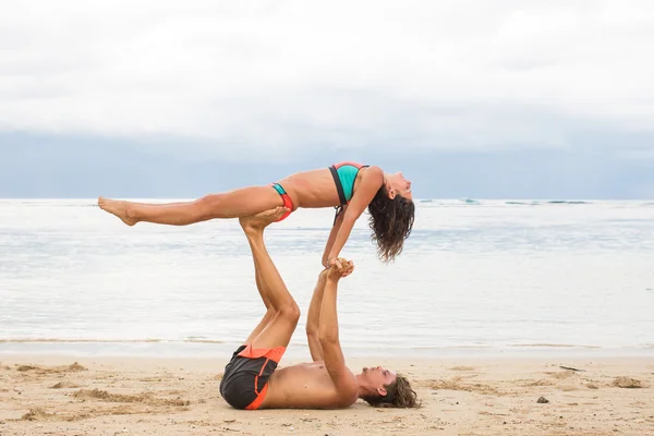 若いカップルでは、熱帯のビーチでの信頼の演習します。 — ストック写真