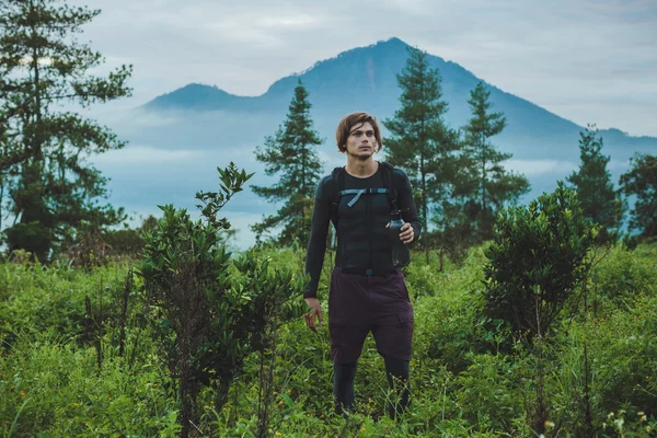 Outdoor portrait of Young man looking on Batur volcano and Agung — Stock Photo, Image