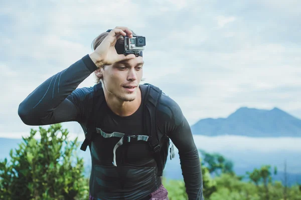 Привлекательный путешественник с камерой GoPrO на руке против Ба — стоковое фото