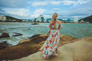 Okyanus kıyısında bir mavi elbiseli güzel kadın