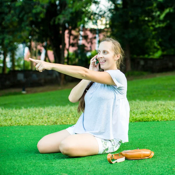 Mujer bonita usando su teléfono en el parque — Foto de Stock