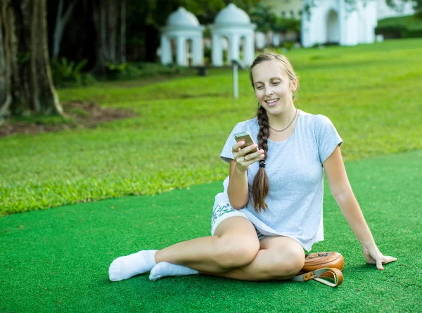 Pretty Woman pomocí její telefon v parku — Stock fotografie