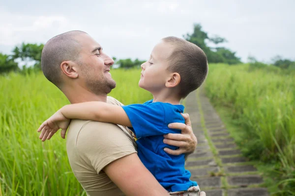 Joven padre feliz sosteniendo en sus brazos pequeño hijo —  Fotos de Stock