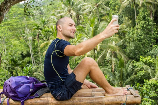 Muž, turistika užívání selfie s chytrý telefon. Šťastný mladý muž takin — Stock fotografie