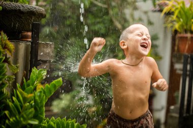 Yağmur altında oynayan sevimli bebeğim