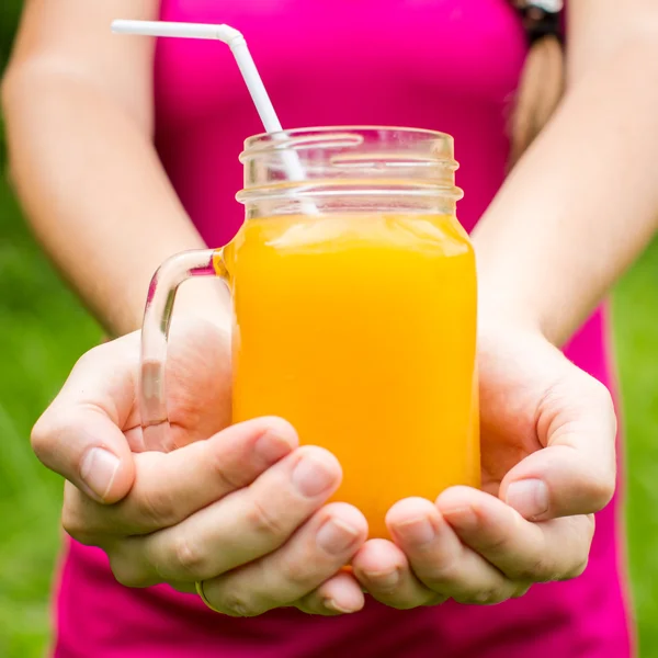 Mujer fitness sosteniendo un vaso de jugo de naranja — Foto de Stock
