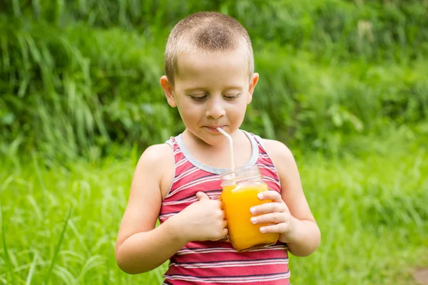 Niño sosteniendo un vaso de jugo de naranja — Foto de Stock