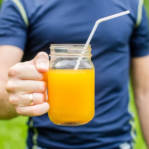 Γυμναστήριο άνδρα να κρατάει ένα ποτήρι χυμό πορτοκάλι — Φωτογραφία Αρχείου