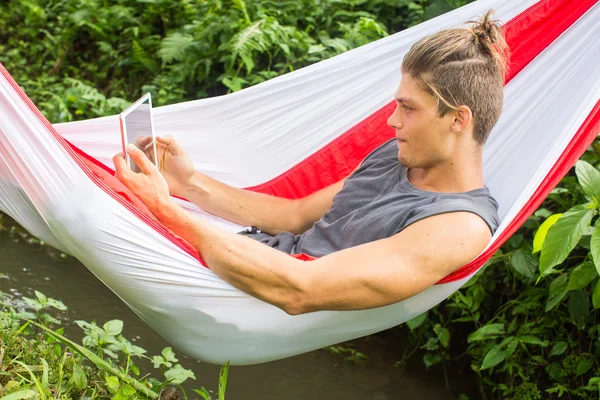 Homme dans l'hamac travaillant sur l'ordinateur portable pendant les vacances d'été . — Photo