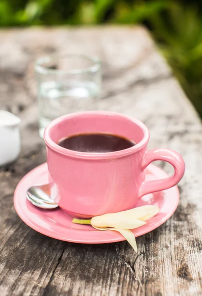 Xícara de café rosa na mesa de madeira — Fotografia de Stock