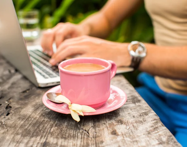 Tiro cortado das mãos de um homem digitando em um laptop que está em um wo — Fotografia de Stock