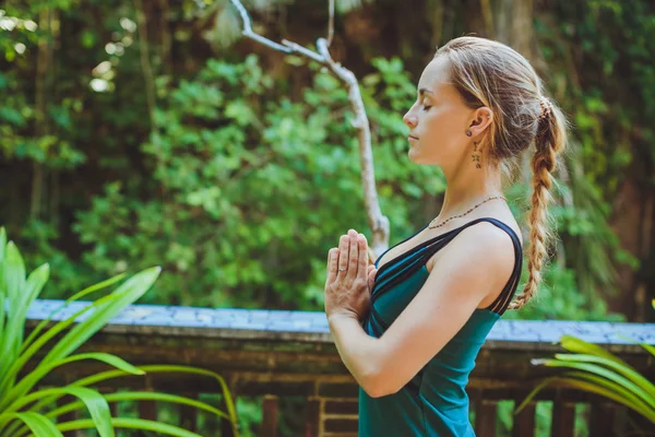 Mujer joven haciendo yoga al aire libre en un entorno natural — Foto de Stock