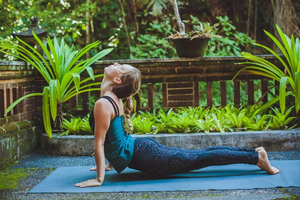 Mujer joven haciendo yoga al aire libre en un entorno natural — Foto de Stock