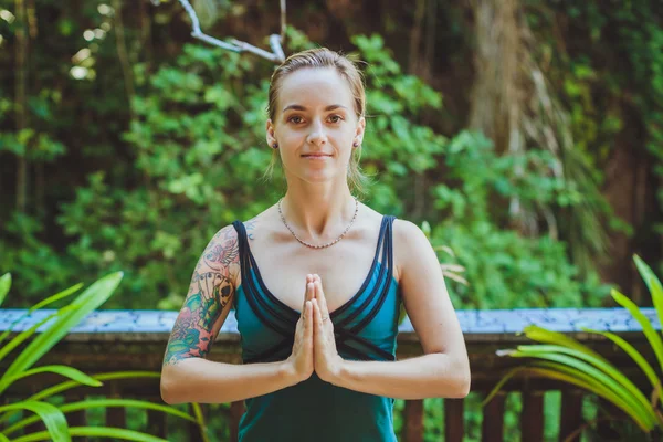 Mujer joven haciendo yoga al aire libre en un entorno natural — Foto de Stock