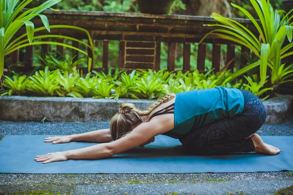 Mujer joven haciendo yoga al aire libre en un entorno natural — Foto de Stock