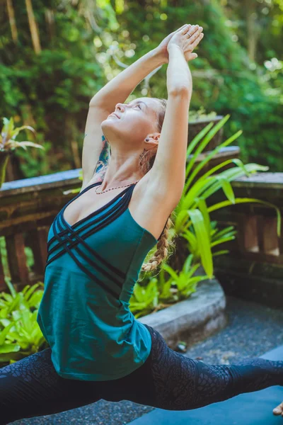 Mujer joven haciendo yoga al aire libre en un entorno natural — Foto de Stock