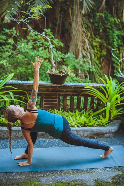 Mujer joven haciendo yoga al aire libre en un entorno natural — Foto de Stock