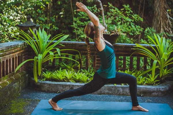 Mujer joven haciendo yoga al aire libre en un entorno natural — Foto de Stock