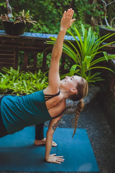 Mujer joven haciendo yoga al aire libre en un entorno natural — Foto de Stock