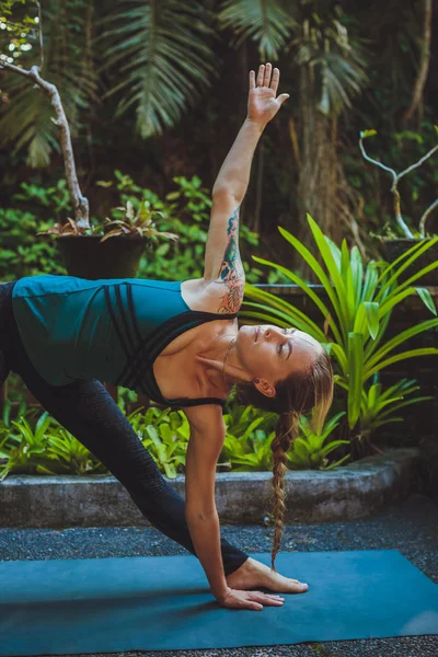 Mujer joven haciendo yoga al aire libre en un entorno natural — Foto de Stock