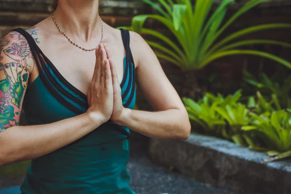 Uma jovem mulher fazendo meditação ao ar livre em ambiente tranquilo — Fotografia de Stock