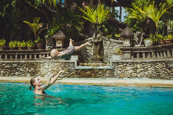 हिप्स्टर आई स्विमिंग पूल, बालीमध्ये तिच्या सुंदर मुलाबरोबर खेळते — स्टॉक फोटो, इमेज