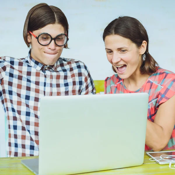 Здивована молода пара ботанік в окулярах дивиться на монітор комп'ютера — стокове фото